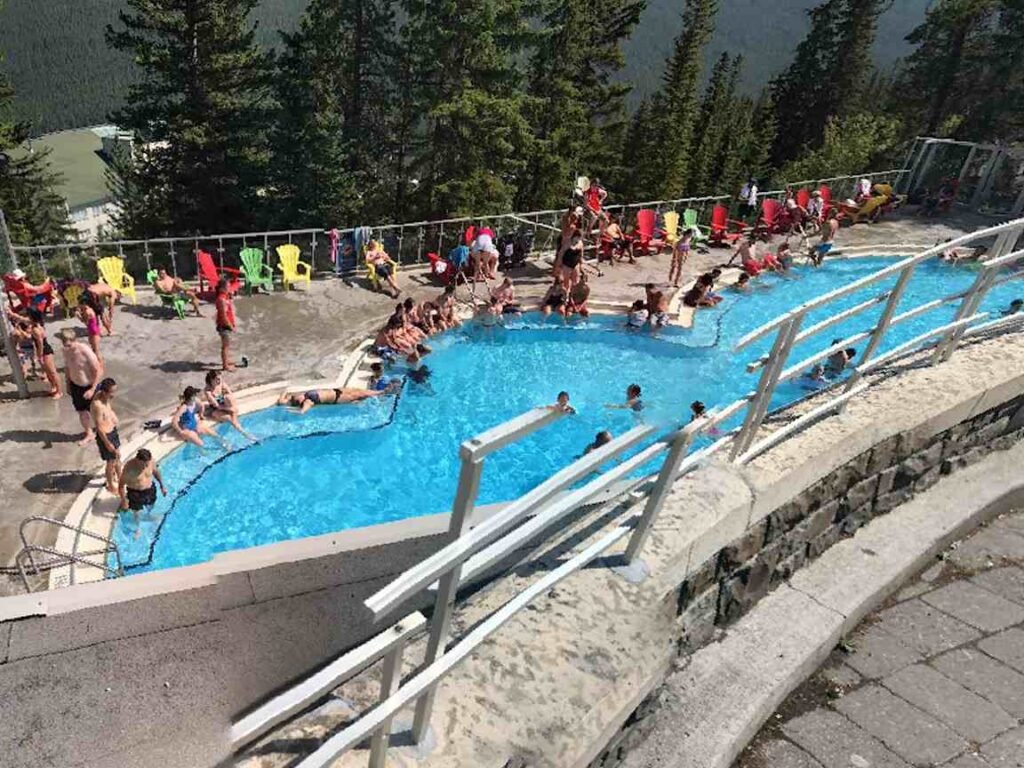 Modern photo of visitors soaking in the Banff Upper Hot Springs pool, a current highlight in its Canadian history