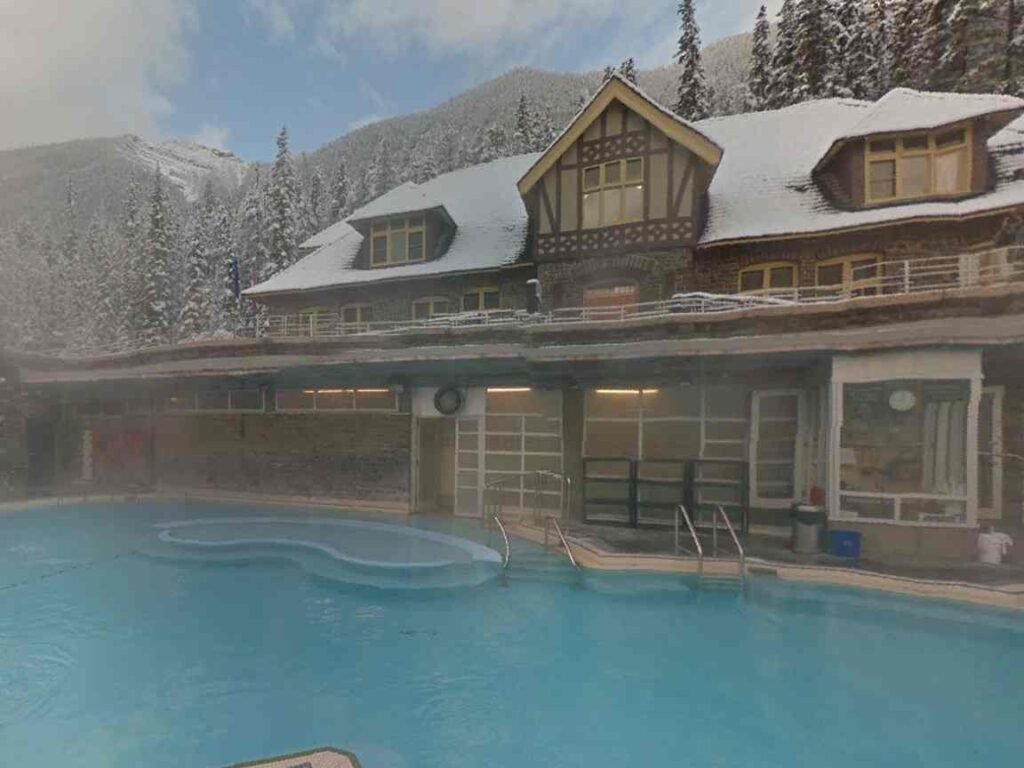 Winter scene at Banff Upper Hot Springs with snow and steam creating a cozy atmosphere